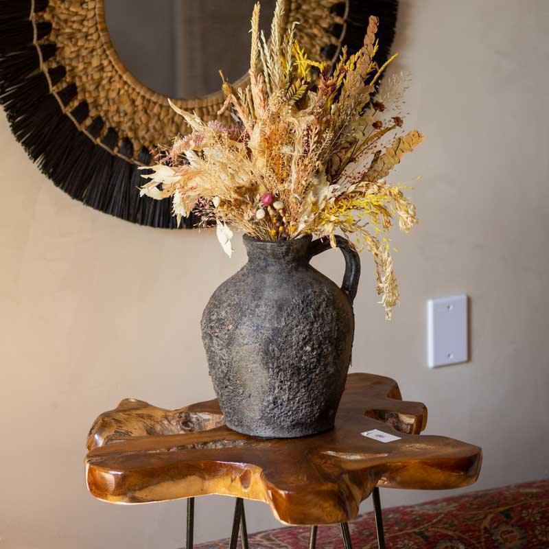 Jarro de cerâmica artesanal balinês com superfície rugosa e tonalidade escura para decoração luxo rústico.