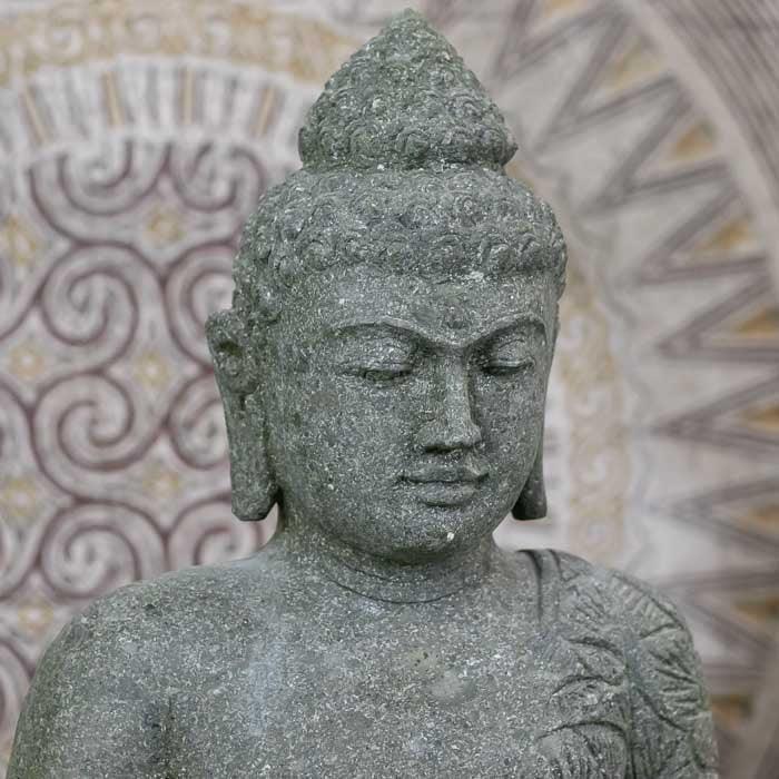 Estátua de Buda esculpida em pedra vulcânica de Bali com expressão meditativa e acabamento natural para decoração zen