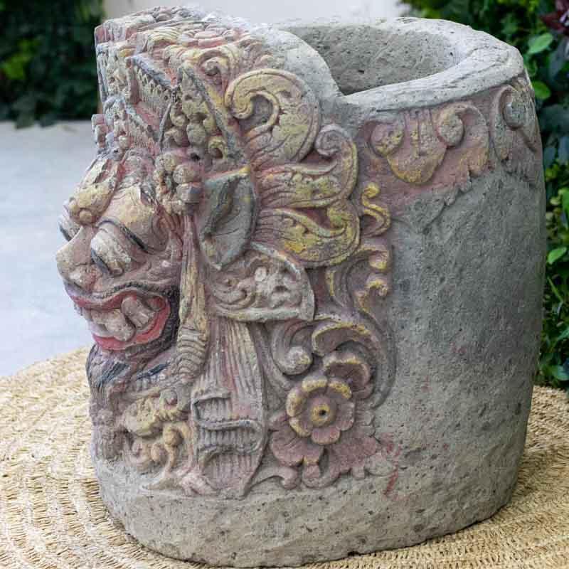 Escultura de jardim em pedra natural com formato de vaso, celebrando a arte sacra e a cultura protetora da Indonésia.
