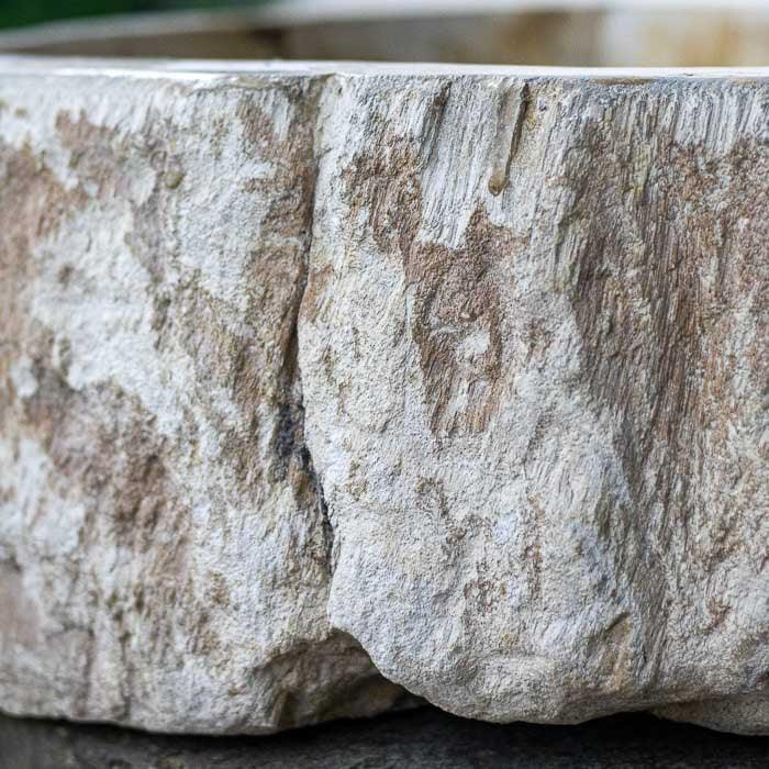 Peça balinesa feita de madeira fossilizada, com visual elegante e rústico.