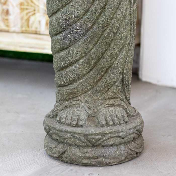 Escultura artesanal de Buda em pedra, com detalhes finos no rosto e nas vestes.