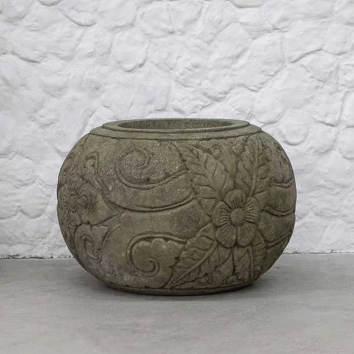 Vaso esférico em pedra vulcânica cinza com entalhes florais em alto-relevo esculpidos à mão.