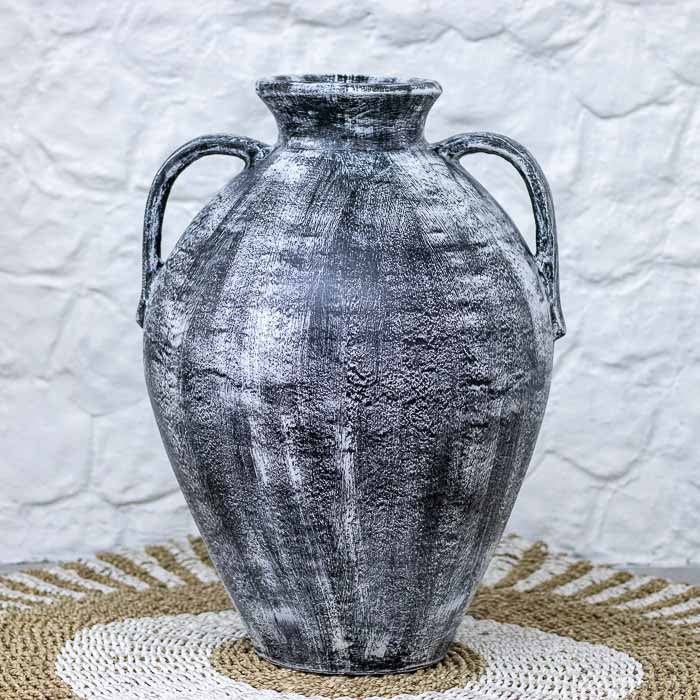 Vaso tipo ânfora em terracota de Bali com acabamento artesanal em pátina branca sobre fundo preto e duas alças laterais clássicas.