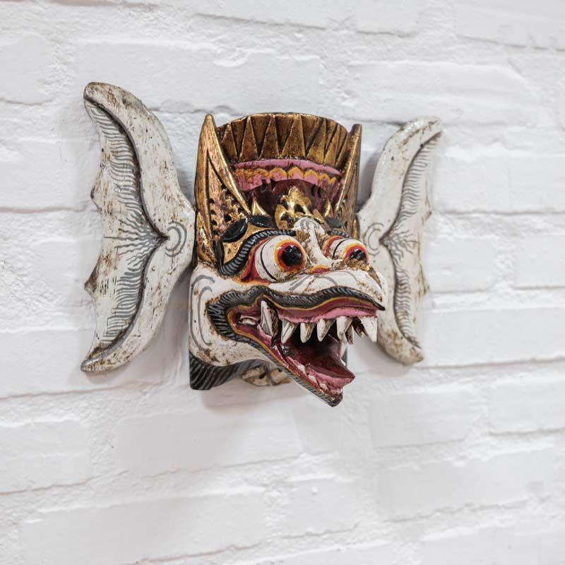 Máscara de parede artesanal Rangda entalhada em madeira com detalhes dourados e expressão mística de Bali.