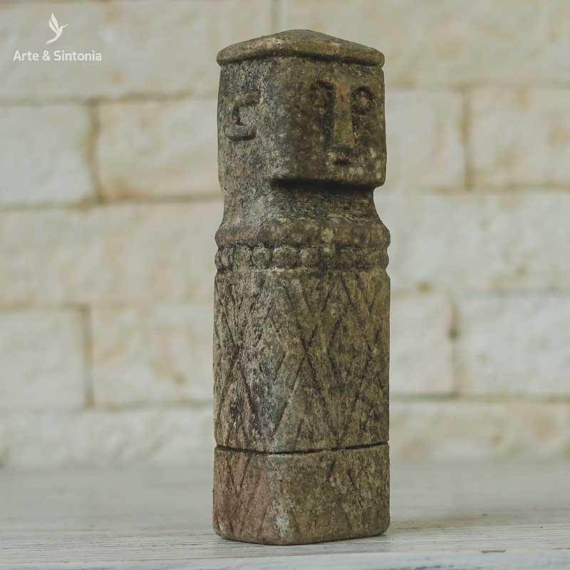 Escultura artesanal com detalhes entalhados e textura rústica