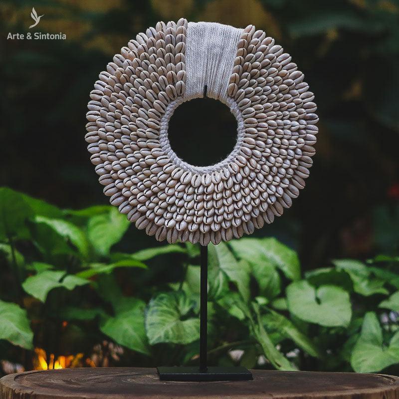 Colar decorativo artesanal de búzios étnico no pedestal de Bali.