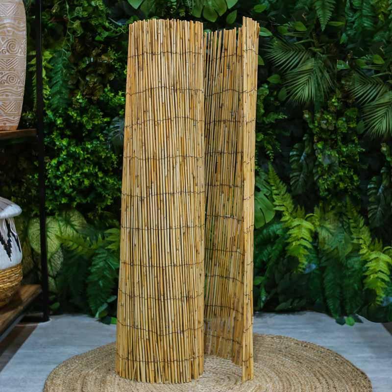 Divisória artesanal de bambu natural em rolo, exibindo a trama vertical das varas unidas por fios resistentes.
