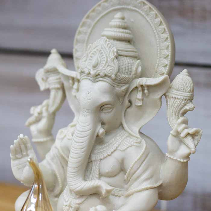 Close-up da luminária Ganesha evidenciando o acabamento frio e sofisticado do marmorite em ambiente decorado.