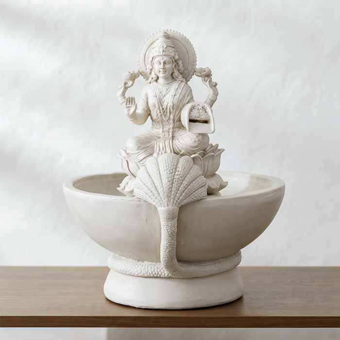 Fonte de água em marmorite da Deusa Lakshmi com iluminação LED destacando o fluxo da água sobre a base de lótus.