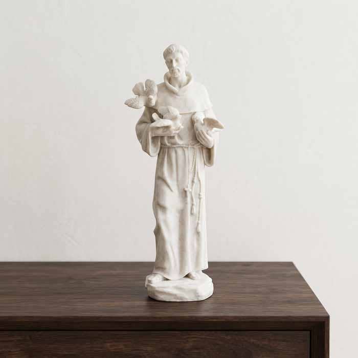 Escultura religiosa de São Francisco de Assis em pé feita em marmorite branco leitoso do Brasil.