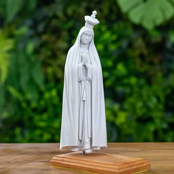 Escultura branca de Nossa Senhora de Fátima com base clara