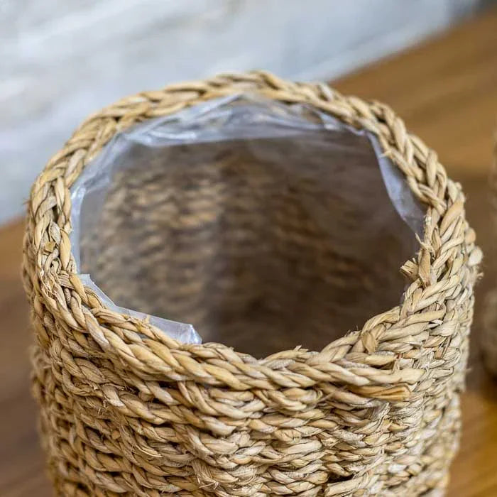 Objeto decorativo em fibra trançada, ideal para vasos e organização. 