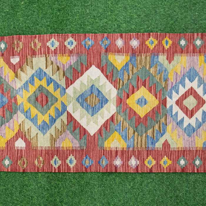 Passadeira Kilim em tear tradicional com padrões geométricos exclusivos.