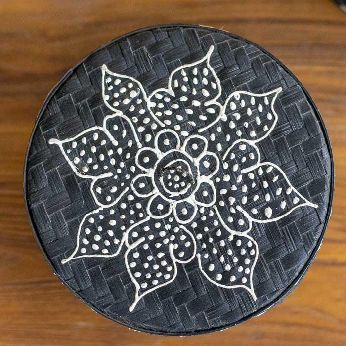 Peça organizadora em bambu com textura natural e padrões geométricos. 