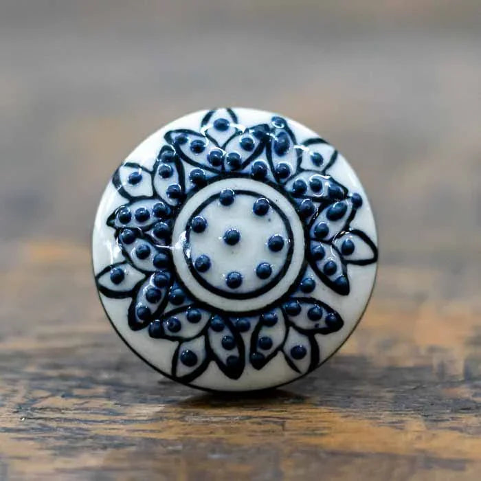Puxador decorativo em cerâmica indiana com relevo floral em preto e branco.