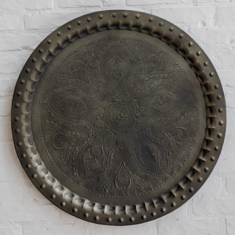 Mandala de parede circular em metal escuro com entalhes florais detalhados de origem indiana.