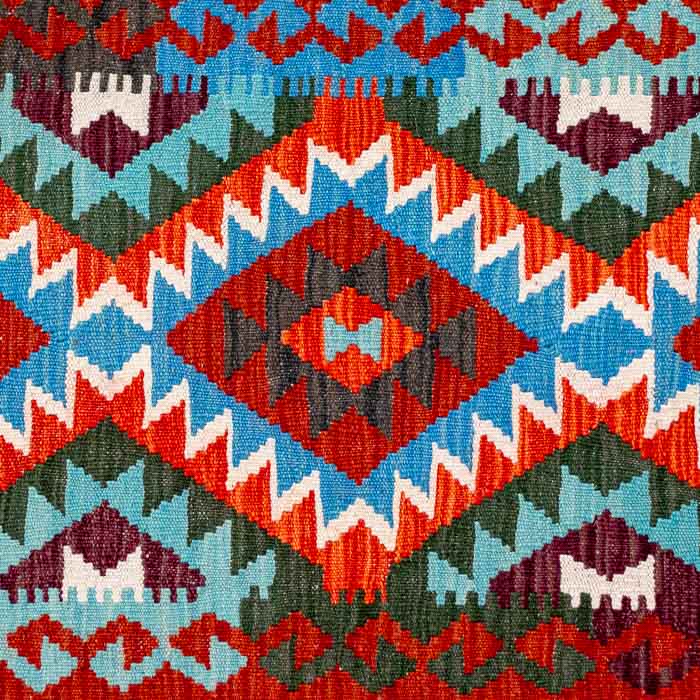 Passadeira artesanal Kilim do Afeganistão apresentando grafismos étnicos multicoloridos sobre trama manual plana de lã.