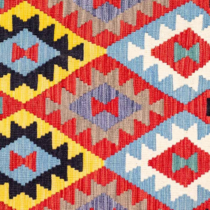Passadeira Kilim afegã artesanal com padronagem geométrica colorida em tons de vermelho, azul e amarelo.