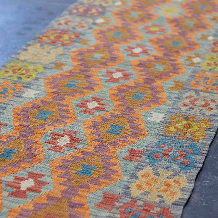 Detalhe da trama plana artesanal de passadeira Kilim em fibras naturais de lã.