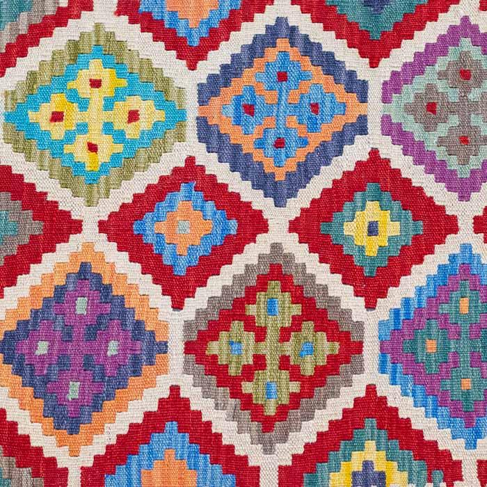 Passadeira geométrica Kilim tecida à mão com padrões de losangos coloridos sobre fundo claro.