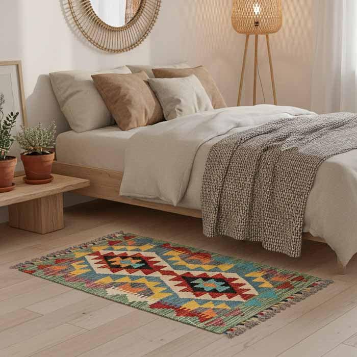 Peça Kilim afegã oriental de 91x61cm em dormitório com móveis claros e design orgânico exclusivo ao pé da cama.