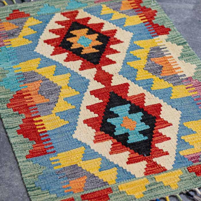 Tecelagem manual do Afeganistão em tapete rústico vibrante pequeno para composição de interiores de alto padrão.