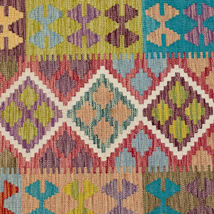 Tapete artesanal Kilim do Afeganistão apresentando grafismos étnicos simétricos sobre trama manual plana de lã natural.