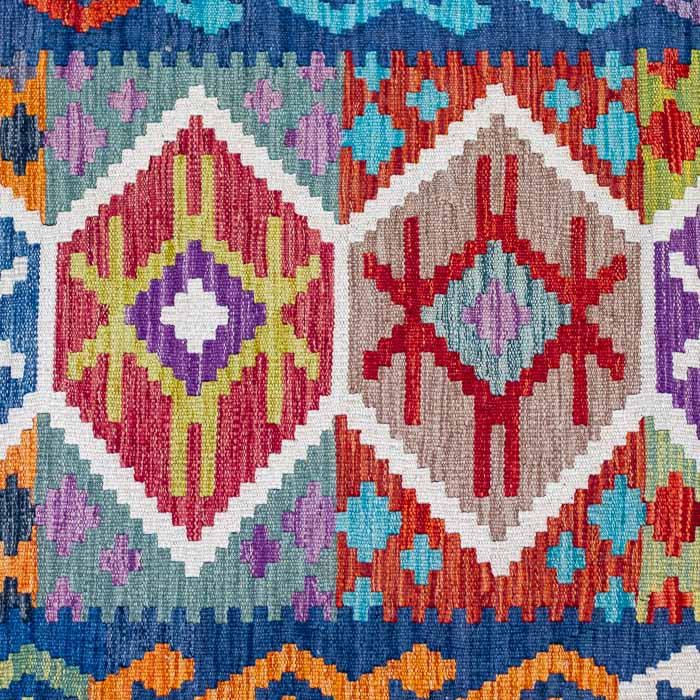 Passadeira Kilim afegã artesanal com bordas azuis e losangos coloridos geométricos.