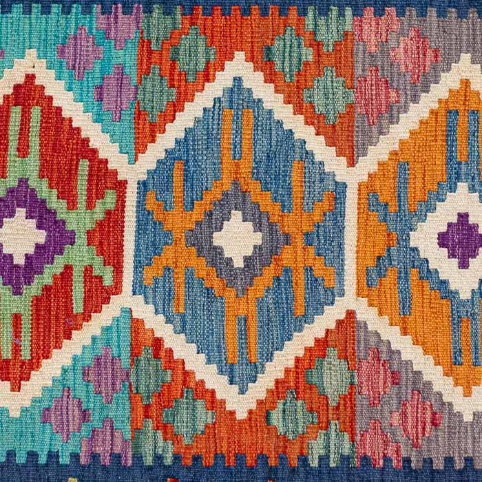 Passadeira artesanal Kilim do Afeganistão com grafismos geométricos étnicos coloridos e técnica de tecelagem plana manual.