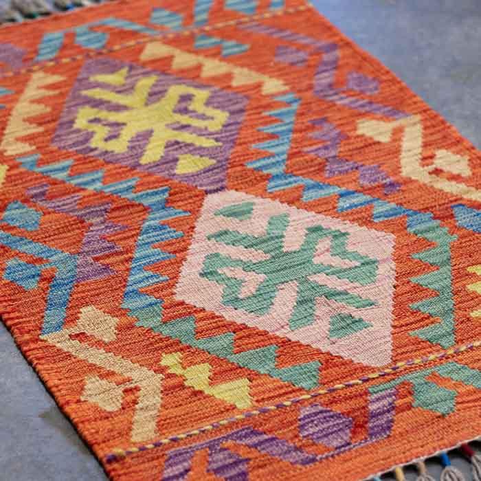 Composição de interiores de alto padrão com tapete Kilim exclusivo do Afeganistão para ambientes de leitura e meditação.