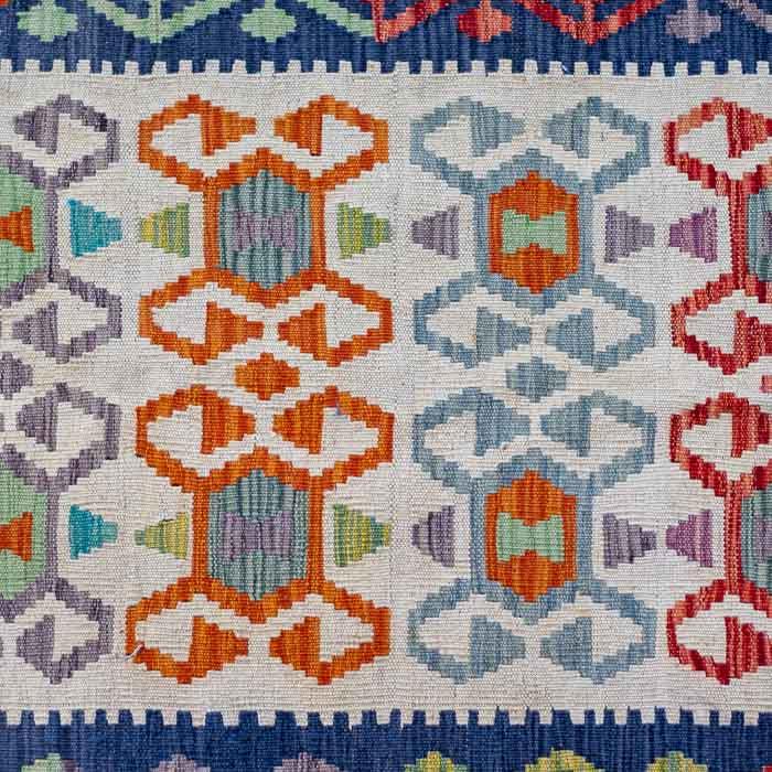Tapete Kilim afegão tecido manualmente com fundo claro e padrões geométricos coloridos.