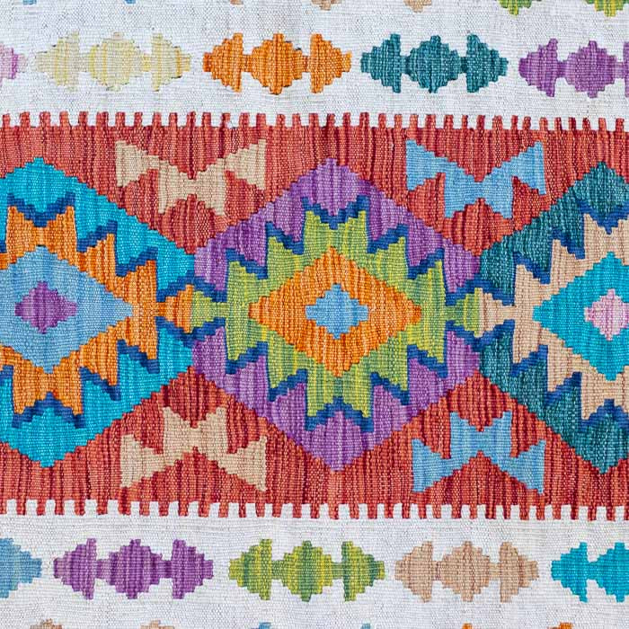 Tapete Kilim afegão feito à mão com padronagem geométrica em tons de terracota, azul e creme.