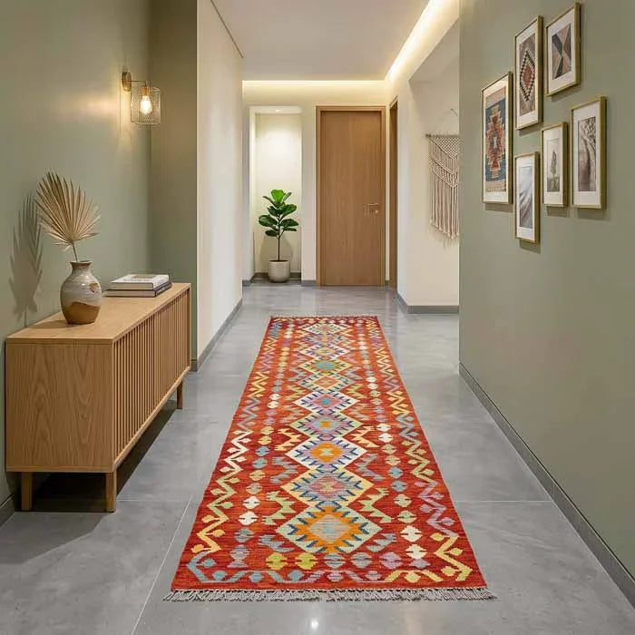 Passadeira Kilim artesanal afegã com padronagem geométrica em tons de terracota e azul.