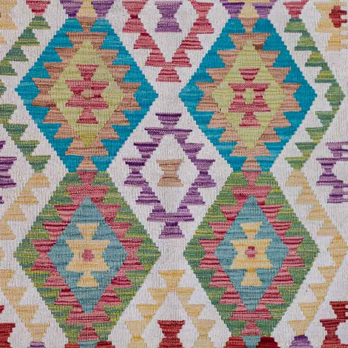 Tapete artesanal Kilim do Afeganistão exibindo padrões geométricos simétricos em cores vibrantes sobre trama manual plana.