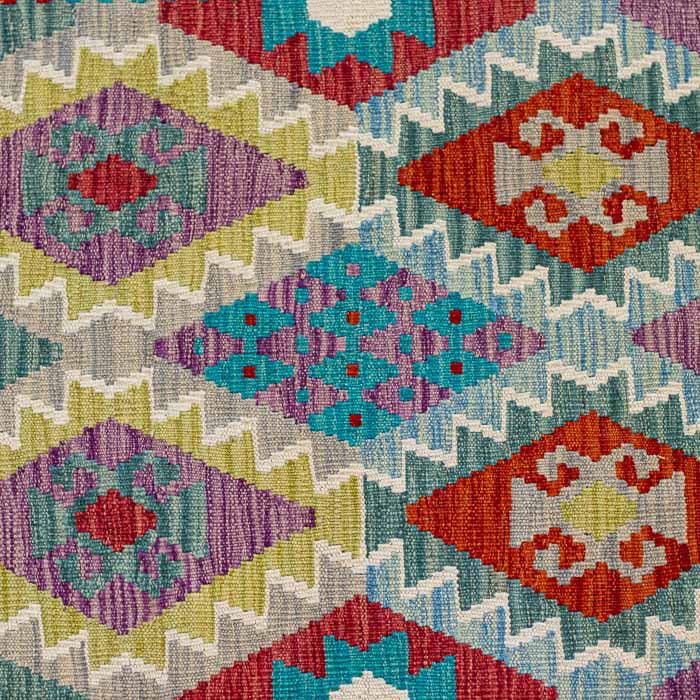Passadeira artesanal Kilim do Afeganistão apresentando grafismos étnicos em tons vibrantes sobre trama manual plana.