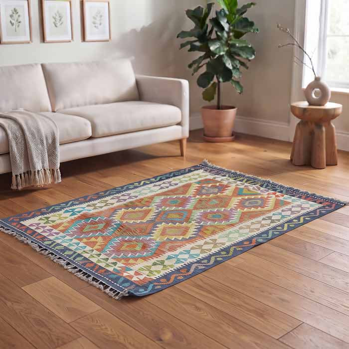 Passadeira oriental de 178cm posicionada em ambiente iluminado com poltrona de vime e plantas, estilo Boho Chic.