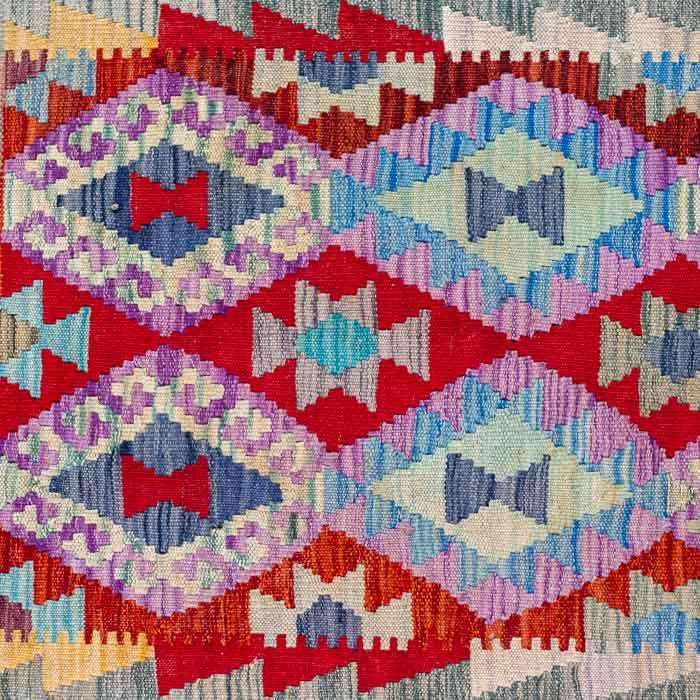 Tapete Kilim afegão feito à mão com padronagem geométrica em tons de vermelho, roxo e azul.