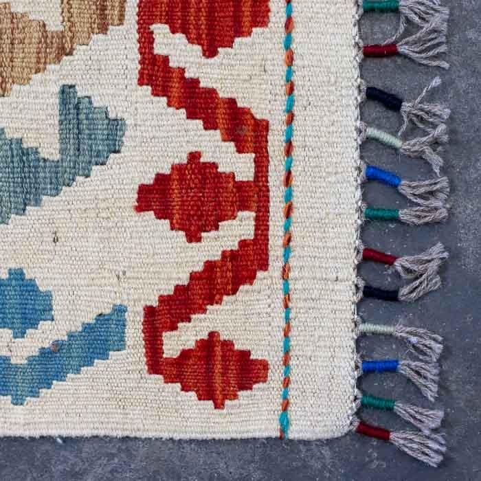 Peça têxtil exclusiva tecida manualmente no Afeganistão com padrões ancestrais e cores vivas.