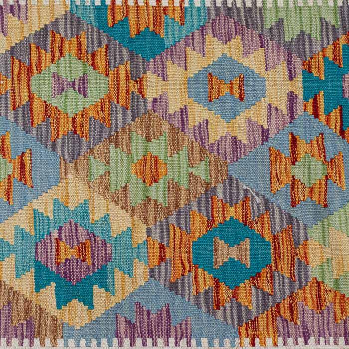 Passadeira artesanal Kilim do Afeganistão com padrões geométricos tribais coloridos e técnica de tecelagem plana manual.
