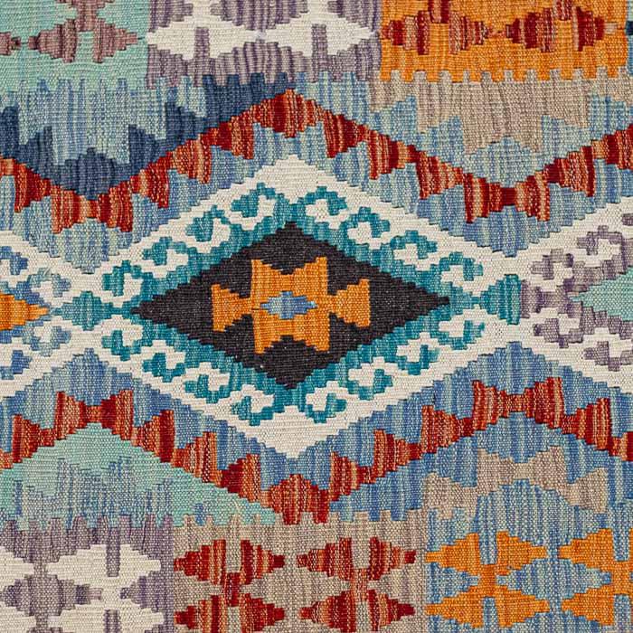 Tapete Kilim colorido do Afeganistão com grafismos geométricos simétricos e técnica de tecelagem manual plana.