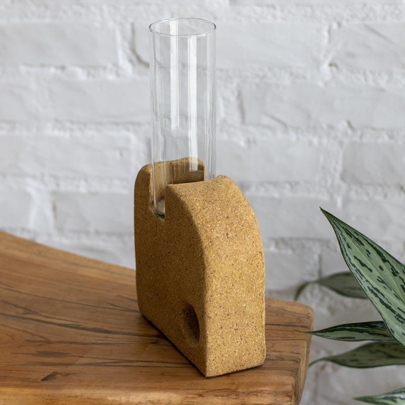 Detalhe de vaso escultório artesanal brasileiro com design assimétrico e orifício circular vazado na base cerâmica.