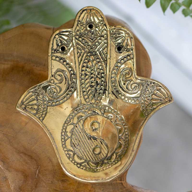 Suporte de incensos em bronze no formato de mão com símbolo yin-yang.