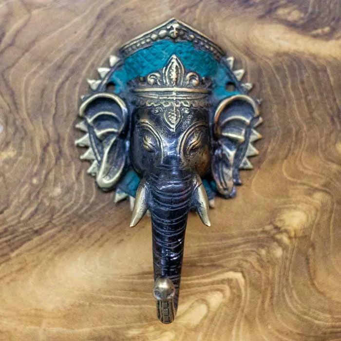 Puxador artesanal de porta Ganesh em bronze com acabamento dourado e preto, produzido manualmente em Bali, simbolizando prosperidade e espiritualidade na decoração. 