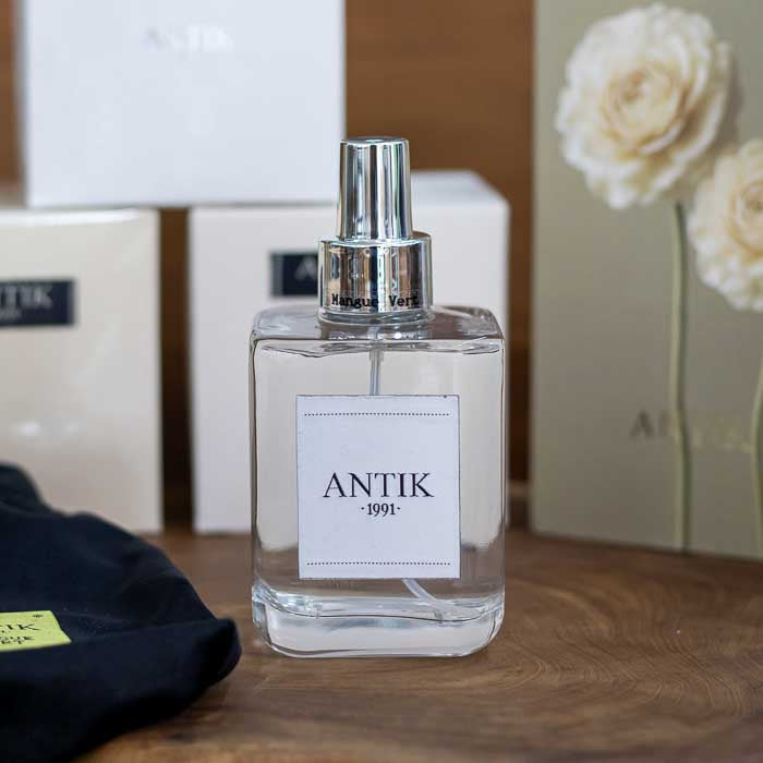 Frasco de vidro transparente do spray para ambiente Antik Mangue Vert com líquido incolor e válvula prata.