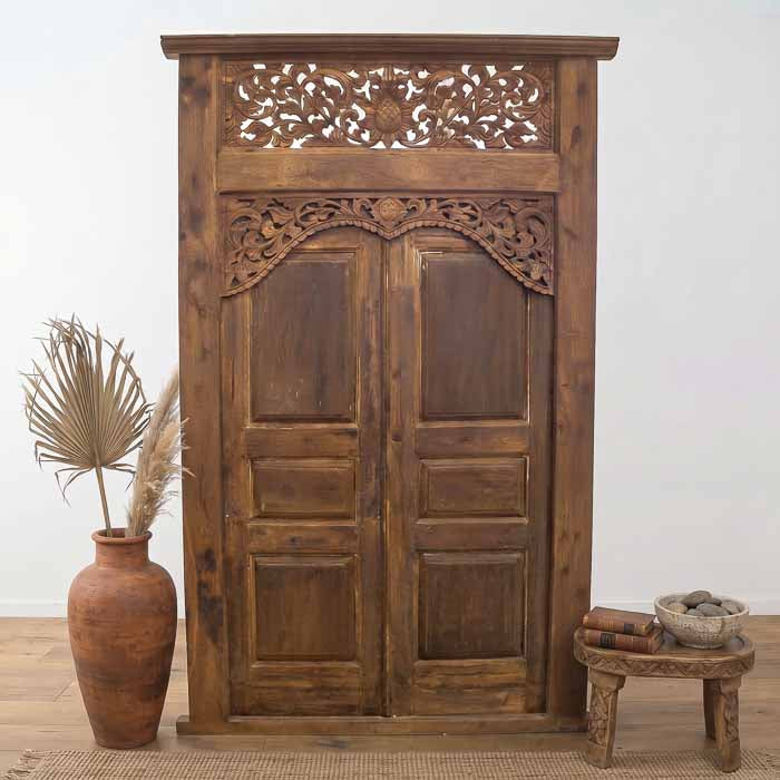 Portal monumental feito à mão em madeira de demolição de Bali com frontão superior entalhado em florais.