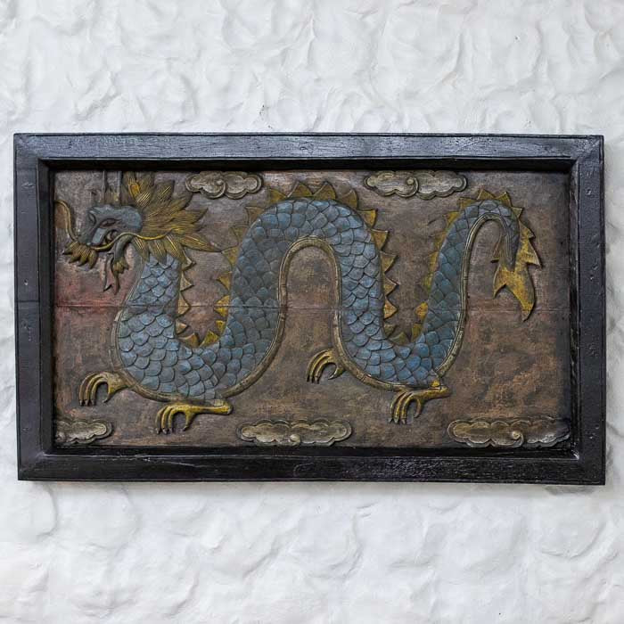 Painel de parede em madeira entalhada apresentando um dragão oriental sinuoso com acabamento antik em tons de azul e dourado.