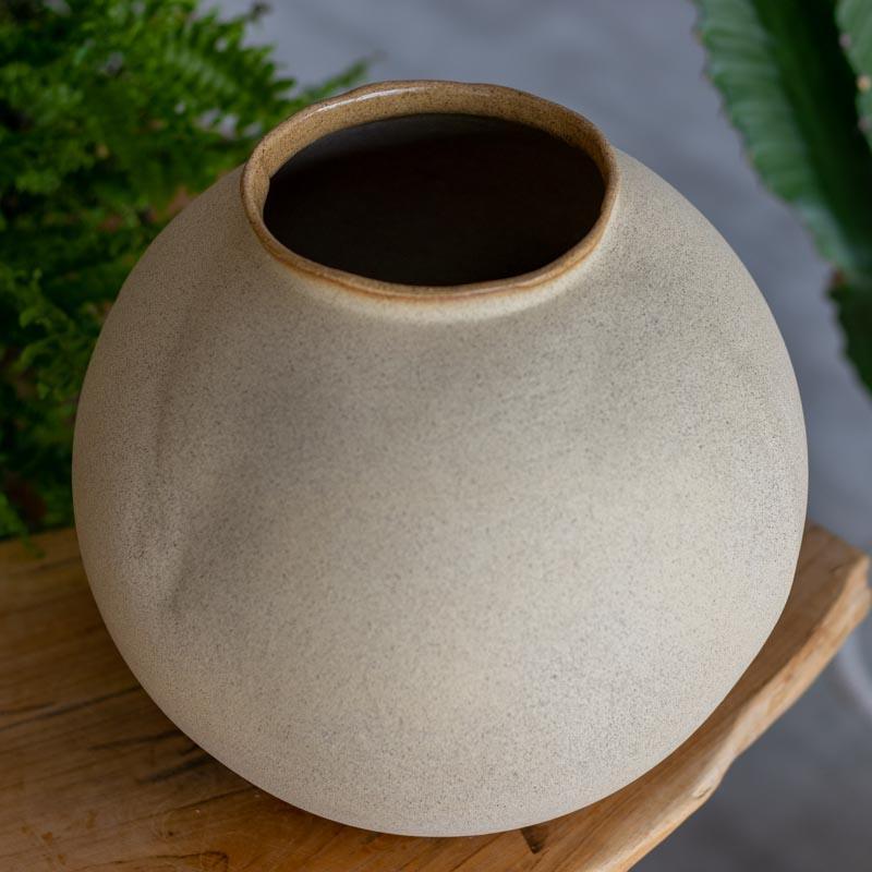 Detalhe da textura orgânica e bocal de vaso brasileiro feito à mão destacando o acabamento rústico e natural do barro.