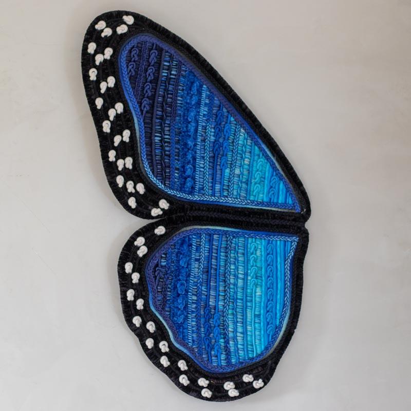 Painel decorativo tridimensional com 91cm de altura, unindo fios de sisal, lã e algodão em uma escultura de parede azul orgânica.