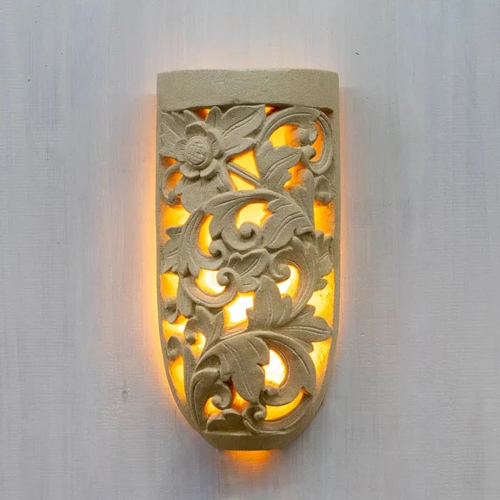 Arandela em limestone com entalhe floral, ideal para iluminação suave e decorativa. 