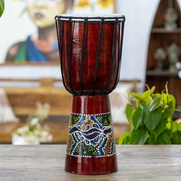 Tambor africano feito em madeira e couro com pintura artesanal de gecko, peça que une simbolismo tribal e expressão musical. 